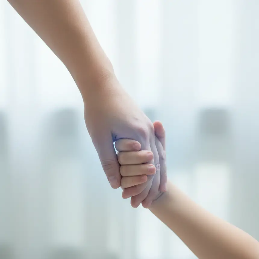 Adult child hands clasped connection